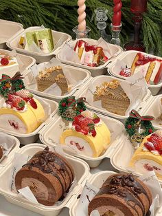 many different types of cakes and deserts in trays on a table with christmas decorations