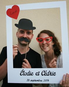 a man and woman pose for a photo with fake moustaches