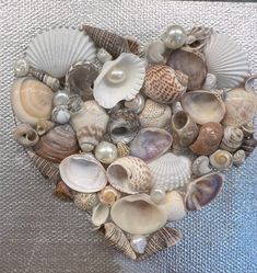 a heart made out of seashells sitting on top of a metal tablecloth