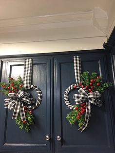 two christmas wreaths are hanging on the front door