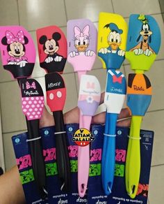 there are many different colored toothbrushes in the hand with cartoon characters on them