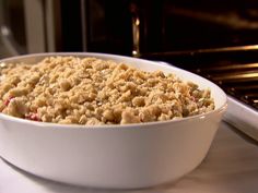 a white bowl filled with food sitting on top of a counter next to an oven