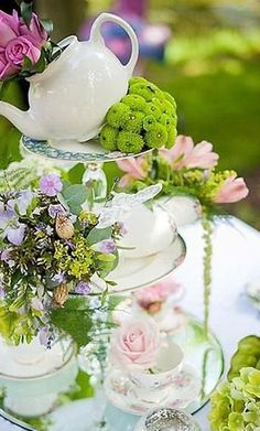 an image of a table setting with flowers and teapots on it, in arabic