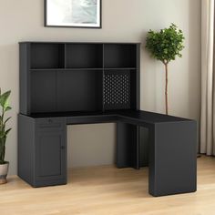 a black corner desk with a potted plant in the corner