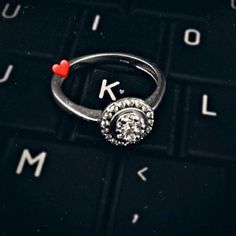 a ring sitting on top of a keyboard with the letter k in it's center