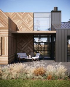 a modern house with wood paneling on the outside and grass in front of it