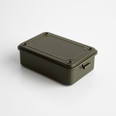 an empty green box sitting on top of a white surface with screws in it