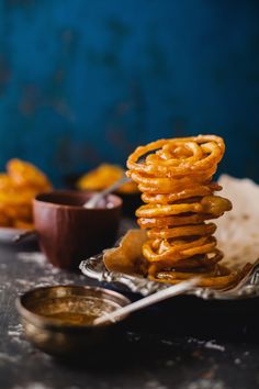 a stack of pretzels sitting on top of a table next to some dipping sauce