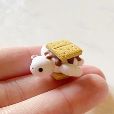 a tiny toy animal with a cracker on it's back sitting in someones hand