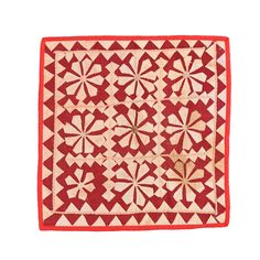 a red and white quilt with many small flowers on it's sides, in the middle