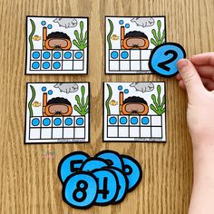 a hand is pointing at four matching cards on a table with the number nine and eight