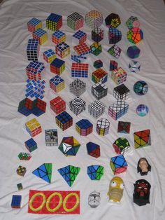 several different colored rubiks and toys on a white sheet