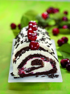 a piece of cake on a plate with cherries