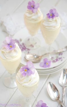 three desserts with white frosting and purple flowers