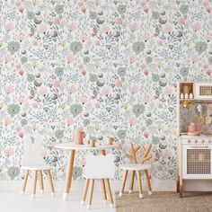 a room with floral wallpaper and two chairs in front of the chair is a small table