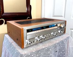 an old fashioned radio sitting on top of a table next to a mirror and door