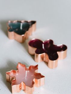 three different colored rings sitting next to each other on top of a white tablecloth