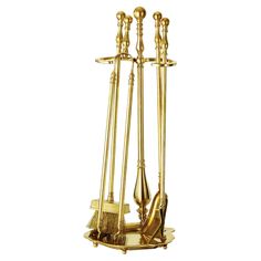 a gold plated metal fireplace tool holder with three tools on the front and one in the back