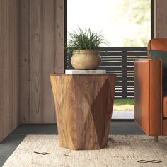 a wooden table with a potted plant sitting on top of it next to an orange chair