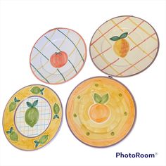 four plates with different designs on them are shown in three different colors and shapes, one is orange, the other has an apple