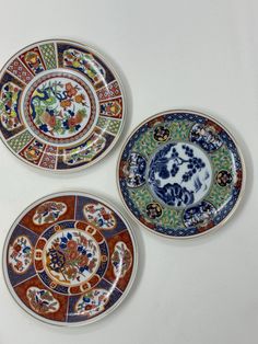 three plates with different designs on them sitting next to each other