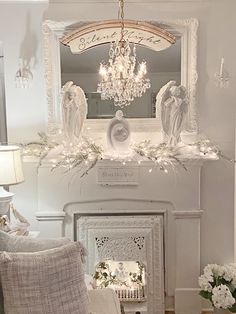 a living room filled with furniture and a chandelier above a fire place in front of a fireplace