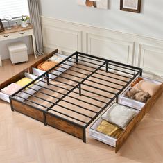 a bed frame with drawers underneath it in a room that has hardwood floors and white walls