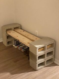 a bench made out of cinder blocks with shoes on the bottom and one foot resting on it