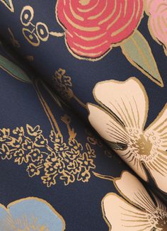 an image of a floral print fabric with gold and blue flowers on navy background, closeup