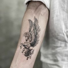 a man with a tattoo on his arm has an eagle and horse in the background