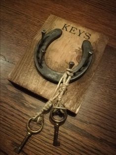 an old pair of scissors tied to a wooden block with the word keys on it