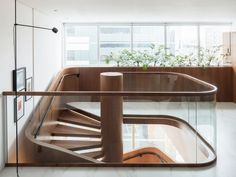 a wooden staircase with glass railing and planters on the wall behind it in a modern home