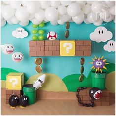 a nintendo themed birthday party with balloons and paper mario's mushroom house on the wall