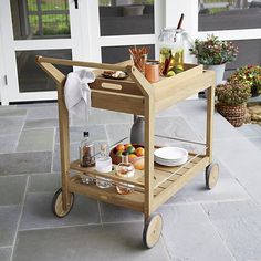 a wooden serving cart with drinks on the front porch for guests to enjoy their meal