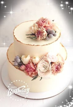 two tiered wedding cake with flowers on top