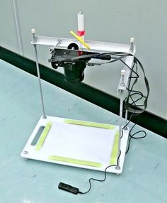 an electronic device with wires attached to it on a table in front of a wall