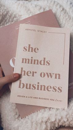 a person holding up a book with the title she minds her own business