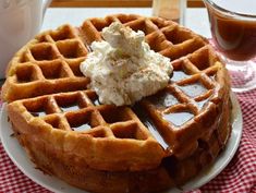 a waffle topped with whipped cream on a white plate