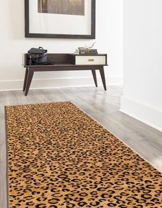 a leopard print rug is on the floor in front of a framed photograph and telephone