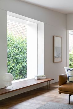 a living room filled with furniture and large windows next to a wooden flooring area