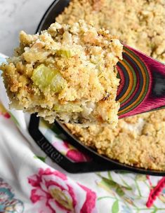 a piece of casserole on a spoon with a serving in the foreground