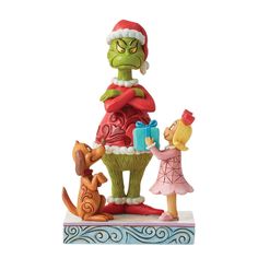 a statue of the grinch and her family is holding presents in front of him