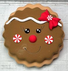 a cookie decorated like a gingerbread man with candy on his eyes and nose, wearing a red bow