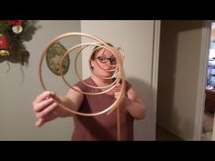 a woman holding a wooden hoop in front of her face