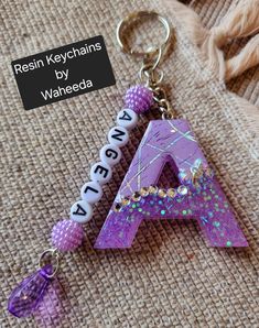 a purple keychain with the letter a on it and a name tag attached to it