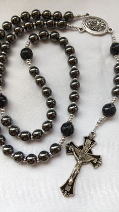 "This is a beautiful, handcrafted men's rosary thoughtfully designed with a St. Joseph centerpiece, the Patron Saint of husbands, fathers, and workers. The rosary includes a black enamel cross from Italy, plated Hematite Beads, and Lava Stones. The rich dark colors make it a gorgeous, yet masculine piece. It is heavy weight and would make a wonderful gift! Perfect for wedding, new father, Father's Day, RCIA, anniversary or any other special occasion!  - Crucifix: 1.75-inch Black Enamel Crucifix Mens Rosary Necklace, Rosary Design, Beautiful Rosaries, Mens Rosary, Logger Boots, New Father, Rosary Beads Catholic, Enamel Cross, New Fathers