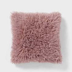 a pink fluffy pillow on a white wall