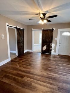 an empty living room with wood flooring and sliding glass doors on the front door