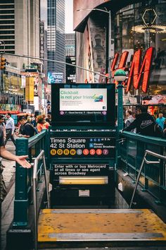 people are walking down the street in front of a large sign that reads times square