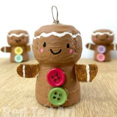 a group of gingerbread man ornaments with buttons on them sitting on a wooden table